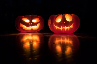 Two lit halloween jack o'lanterns