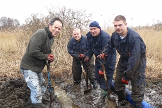 A group of friends dig in the mud