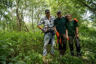 Volunteers holding hand tools at a volunteer session at Papercourt Marshes.