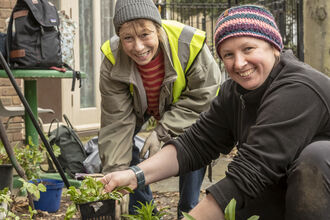 Two ladies planting up pond plants 