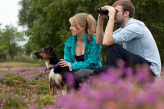 Couple birdwatching with dog