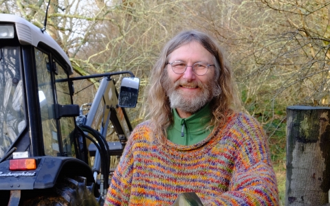 Rob standing next to a tractor holding wire