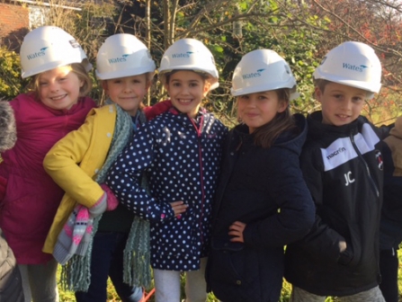 School children wearing Wates hard hats