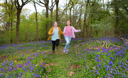 Children running in bluebells