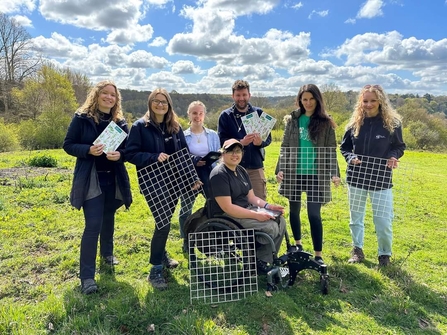 A group image of a team posing with quadrats used to survey vegetation.