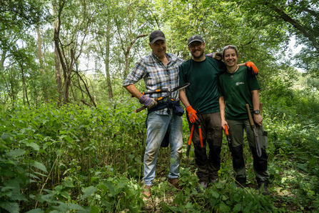 Volunteers holding hand tools at a volunteer session at Papercourt Marshes.