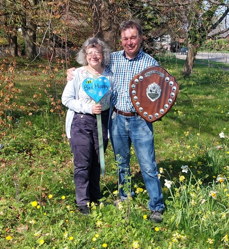 Steve and Diane holding trophy and blue heart 