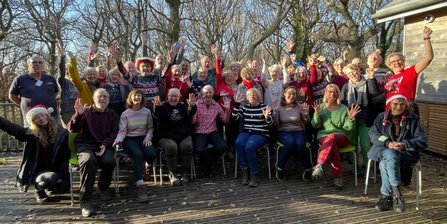 Volunteers dressed in festive outfits looking cheerful at a volunteer celebration day
