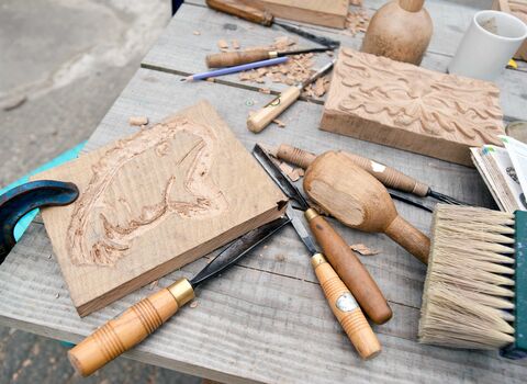 A wood carving of a toad during a workshop